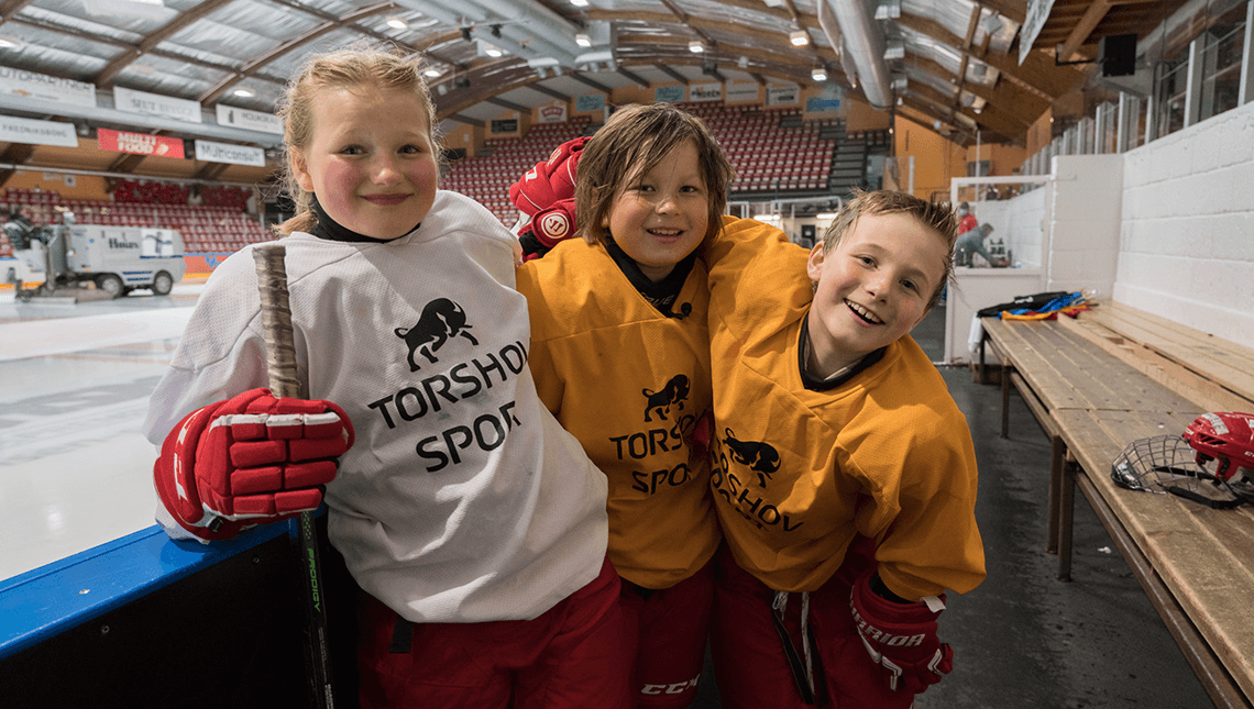 Tre barn i ishockeyutstyr